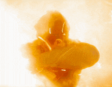 a silhouette of a man in a yellow costume is surrounded by smoke
