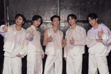 a group of young men are posing for a picture and one of them is giving a thumbs up sign
