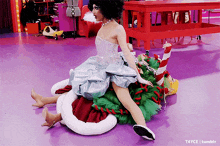 a drag queen is riding on the back of a candy cane .