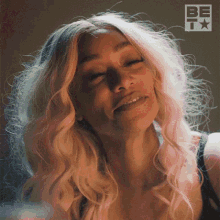 a close up of a woman 's face with a be t logo in the background