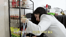 a woman in a suit is standing in front of a shelf full of snacks and drinks