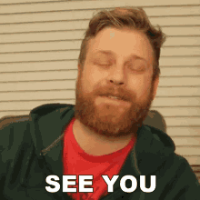 a man with a beard and a green hoodie says see you