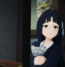 a girl with long black hair is holding a small cat