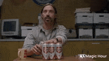 a man is sitting at a table with three cans of lone star beer in front of him .