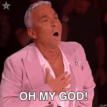 a man in a pink suit says oh my god with his mouth open