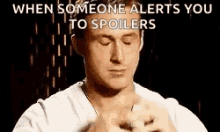 a man is praying with his eyes closed in front of a black background while someone alerts you to spoilers .