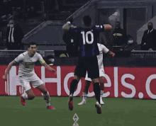 a soccer player with the number 10 on his back jumps to catch the ball