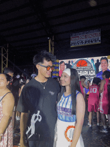 a man and a girl are posing for a picture in front of a banner that says dong gonzales