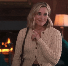 a woman wearing a white sweater is smiling and holding a key