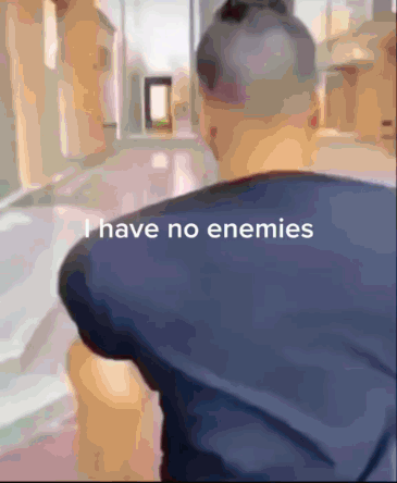 Man bumps into someone, dodges his punch, kisses him on the forehead instead of getting confrontational, and walks away. Captioned: "I have no enemies"