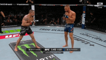 two men are fighting in a boxing ring with a monster energy drink advertisement on the mat