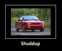 a picture of a red car on a dirt road with the word shuddup below it