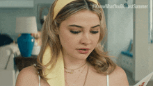 a woman wearing a yellow headband and a necklace with the words i know what you did last summer written on the bottom
