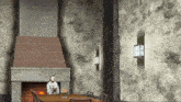 a man is sitting in front of a fireplace in a room