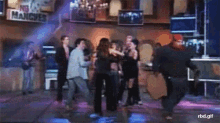 a group of people are dancing on a stage in front of a sign that says hangves