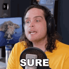 a man wearing headphones stands in front of a microphone with the word sure written on it