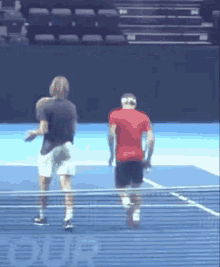 two men are playing tennis on a court with a sign that says #oda