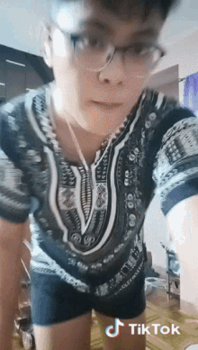 a man wearing glasses and a shirt that says tik tok on the bottom