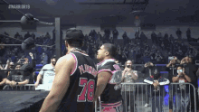 a wrestler with the number 78 on his back is standing next to another wrestler