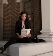 a woman sits on a porch reading a magazine