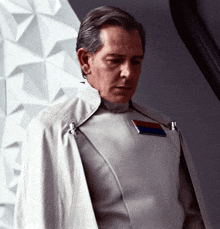 a man in a white uniform has a badge on his chest that says " commander "