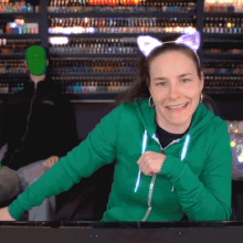 a woman wearing a green hoodie with cat ears on her head