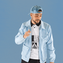 a man wearing a light blue jacket and a white shirt with solary on it