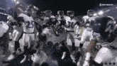 a group of football players are dancing in a stadium .