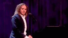 a man in a suit is giving a thumbs up in front of a microphone that says bbc on it