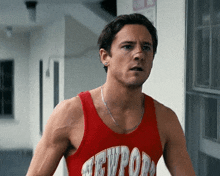 a man is wearing a red tank top that says newport