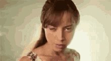 a close up of a woman 's face with a ponytail .