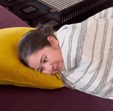 a woman wrapped in a blanket is laying on a bed