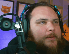 a man with a beard wears headphones and a microphone