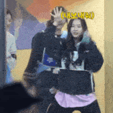 a girl in a pink shirt is dancing with a man in a black jacket and a sign that says chlz chlz