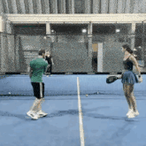 a man and woman are playing tennis on a blue court .