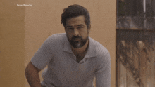 a man with a beard is standing in front of a wall with the words brazilponcho on it