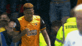 a man in a flamingo land jersey stands in front of a crowd