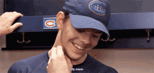 a man wearing a canadiens hat is smiling and talking to his mother