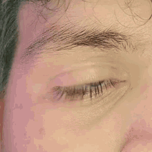 a closeup of a man 's eye with a pink background