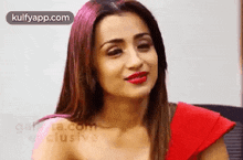a woman in a red dress with red lipstick is smiling .