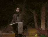 a man with a beard is holding a piece of paper and finishing the hat