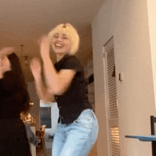 two women are dancing together in a living room .
