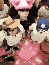 a group of people wearing cowboy hats and police hats are taking a selfie