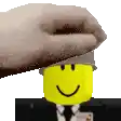a hand is putting a hat on a yellow lego man .
