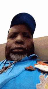 a man with a beard wearing a blue shirt and hat