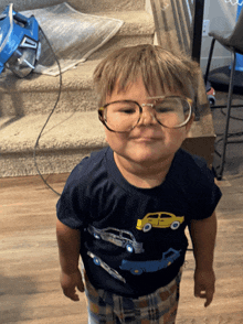 a little boy wearing glasses and a shirt that says cars on it