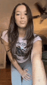 a woman is taking a selfie in a room with a ceiling fan .