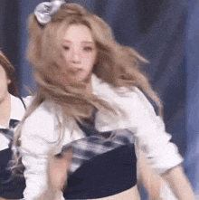 a woman with long blonde hair is dancing on a stage with other women .