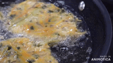 food is being cooked in a frying pan with the words made in animotica on the bottom