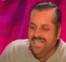 a man with a mustache is smiling with his eyes closed and his mouth open .